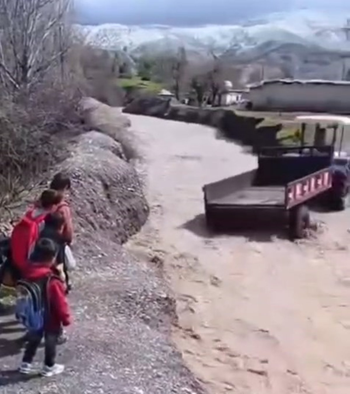 Öğrenciler, debisi yükselen dereyi traktörle geçti