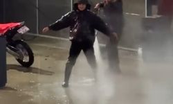 Çamurlu araziden dönen motosiklet sürücüsü, basınçlı suyla temizlendi