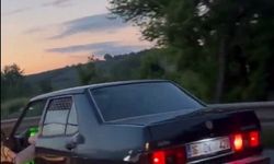 Otomobilinin sol ön kapısını açıp, ayağıyla tutarak trafikte ilerledi