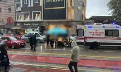 Otomobilin çarptığı yaralıyı yağmurdan korumak için şemsiye tuttular