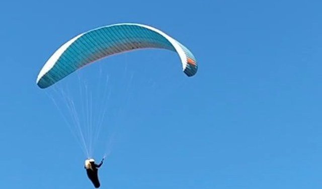 Mahallenin üstünden geçen paraşütçüyü çaya çağırdı
