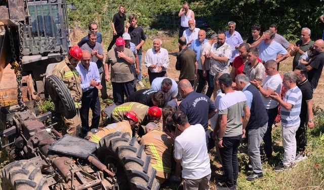 Köprüden düşen traktörün altında kalan sürücü iş makinesiyle kurtarıldı