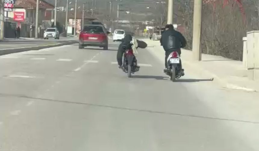 Kasksız sürücünün motosikleti yüzüstü yatarak kullandığı anlar kamerada